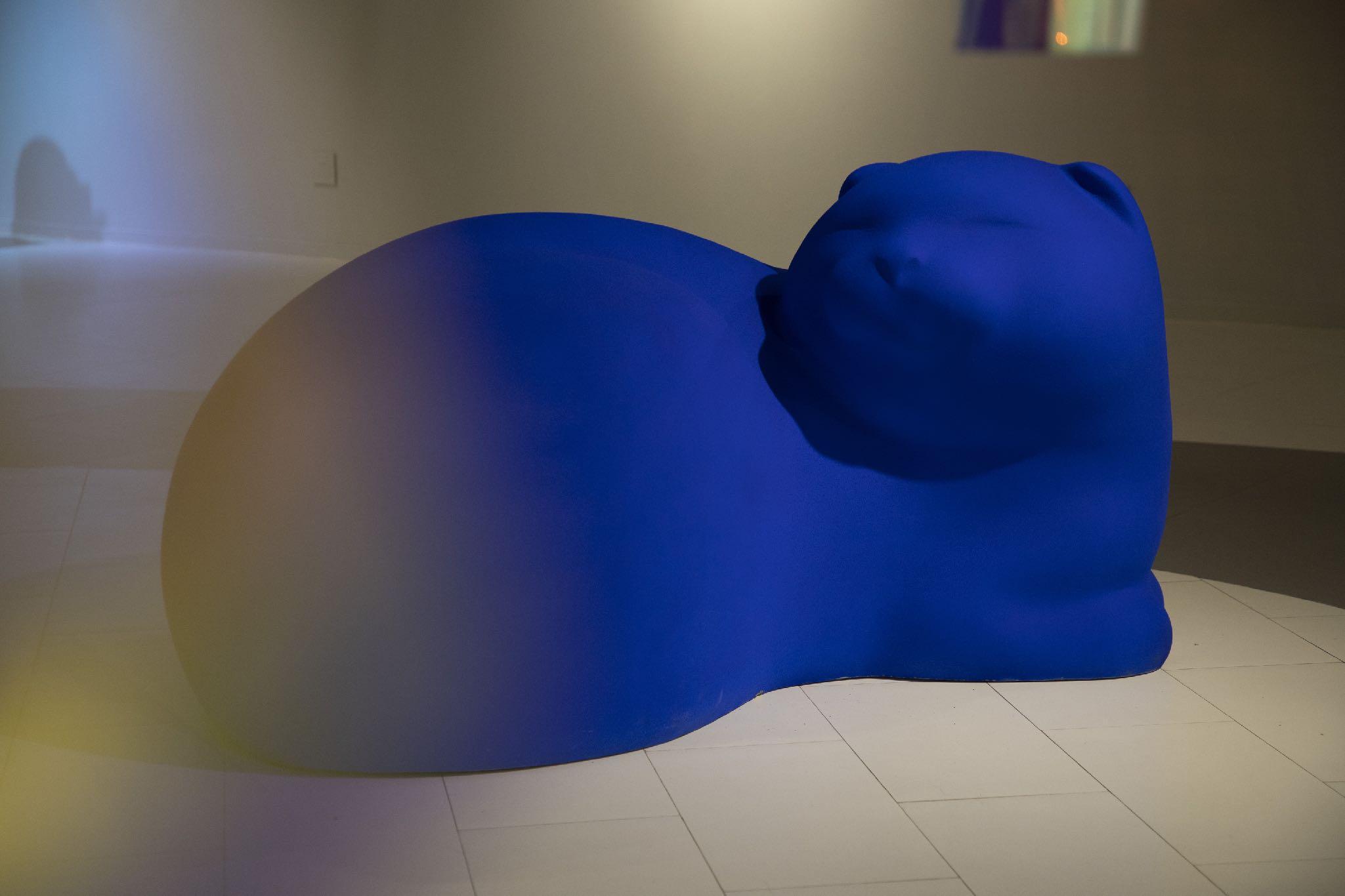 Large rounded blue cat sculpture in an exhibition space