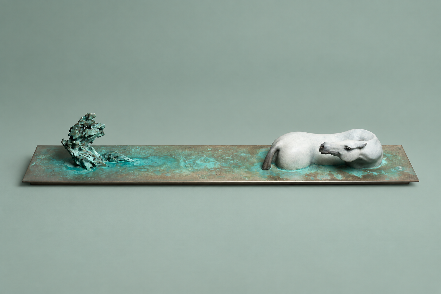 Seeing Mountains: a white reclining horse and rock on a patinated bronze slab